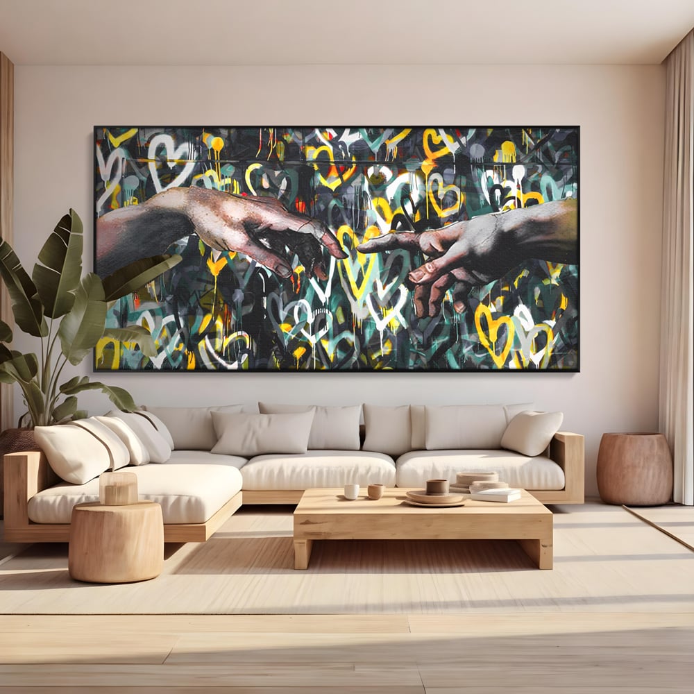 Tablou canvas cu tablou canvas cu maini si inimi, in rama de aluminiu negru, pe perete intr-un living